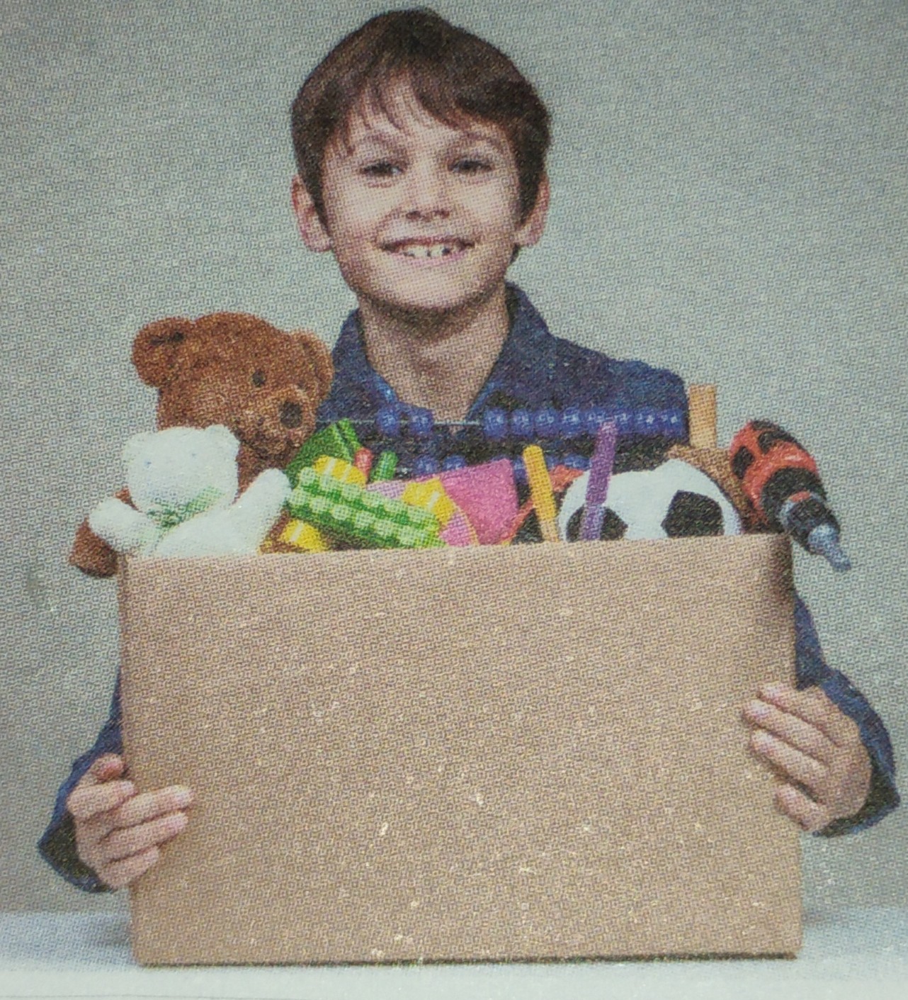 Criança segurando caixa com brinquedos